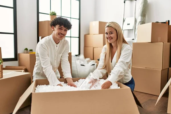 Young Beautiful Couple Smiling Happy Unboxing Cardboard Box New Home — Stock Photo, Image