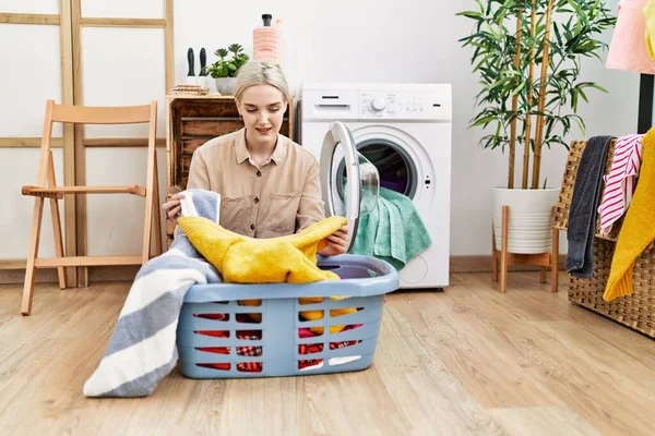 年轻的高加索女人笑着自信地在洗衣房洗衣服 — 图库照片
