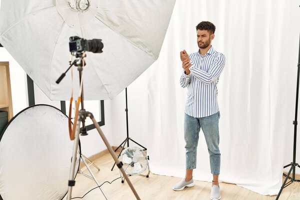 Арабский юноша, изображающий модель в фотостудии, страдает от боли в руках и пальцах, воспаления артрита 