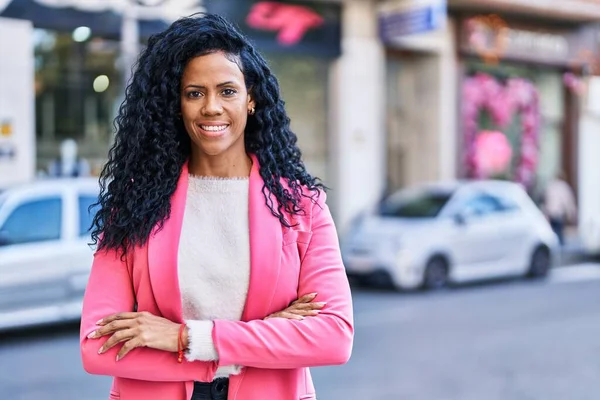 African american woman executive standing with arms crossed gesture at street