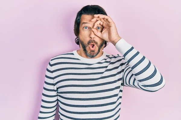 Orta yaşlı, sıradan kıyafetler giyen, şaşırmış yüz ifadesiyle şaşırmış, parmaklarından bakan beyaz bir adam. İnançsız ifade. 