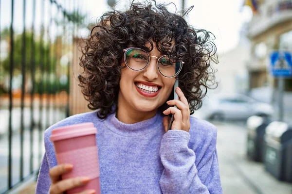 若い中東の女性は路上でスマートフォンで自信を持って話して笑顔 — ストック写真