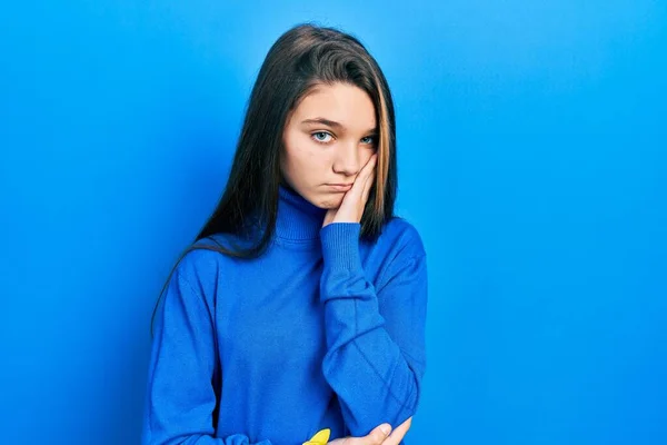 Young brunette girl wearing turtleneck sweater thinking looking tired and bored with depression problems with crossed arms.