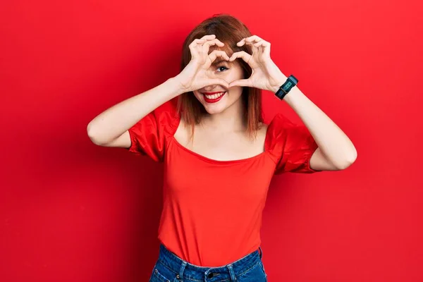 Pelirroja Joven Mujer Usando Casual Camiseta Roja Haciendo Forma Corazón —  Fotos de Stock