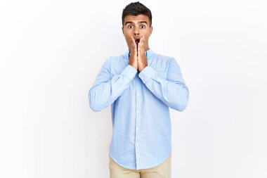 Soyutlanmış arka plan üzerinde duran İspanyol gömlekli genç adam korkmuş ve şok olmuş, şaşırmış ve şaşırmış bir yüz ifadesi vardı. 