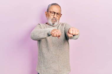 Sakallı, sıradan süveter giyen ve gözlüklü yakışıklı dövüşmek için yumruk atan agresif ve öfkeli saldırı, tehdit ve şiddet dolu. 