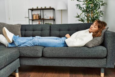 Beyaz bir kadın evdeki kanepede uyuyor.