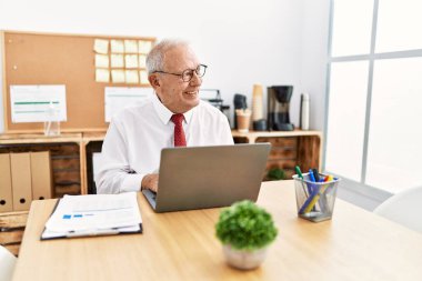 Ofiste çalışan üst düzey bir iş adamı dizüstü bilgisayar kullanıyor.