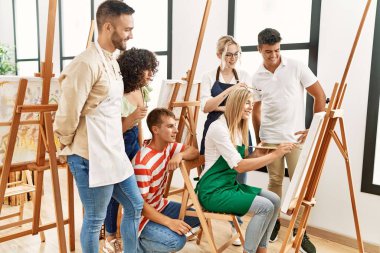 Mutlu gülümseyen ve ortak arayan bir grup insan sanat stüdyosunda..