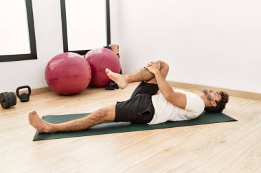 Genç İspanyol adam spor merkezinde geriniyor.