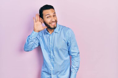 Sakallı, sıradan mavi gömlekli, ağzı kulaklarına varan bir gülümsemeyle dedikoduları ve dedikoduları dinleyen İspanyol bir adam. Sağırlık kavramı. 