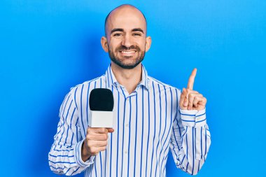 Elinde mikrofon tutan genç kel adam bir fikre ya da soru işaretine şaşırdı. 