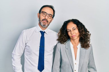 Orta yaşlı bir çift İspanyol kadın ve iş adamı üniforması giyen bir adam ciddi bir ifadeyle rahatlamış. Basit ve doğal bir şekilde kameraya bakıyorsun.. 