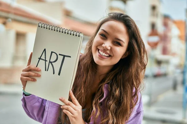 若いヒスパニックアートの学生の女性笑顔幸せな保持ノートブックに市内 — ストック写真