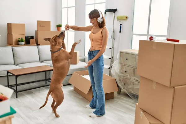 Jonge Kaukasische Vrouw Luisteren Naar Muziek Voeden Hond Thuis — Stockfoto