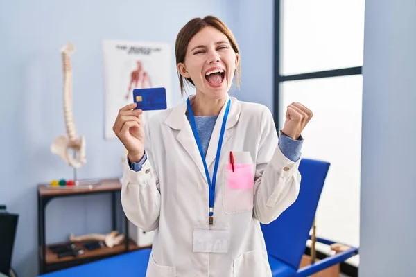 Young Brunette Woman Working Pain Recovery Clinic Holding Credit Card —  Fotos de Stock