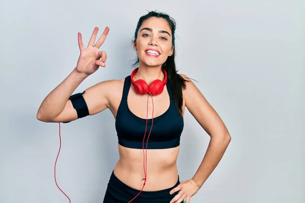 Young Hispanic Girl Wearing Gym Clothes Using Headphones Smiling Positive — 스톡 사진