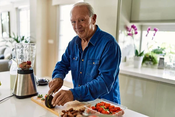 Hombre Mayor Sonriendo Confiado Cortando Aguacate Cocina —  Fotos de Stock