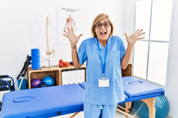 Middle Age Blonde Woman Working Pain Recovery Clinic Celebrating Crazy — Fotografia de Stock