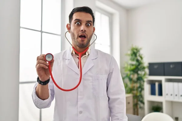 Mladý Hispánský Lékař Muž Vousy Držící Stetoskop Auscultating Strach Šokovaný — Stock fotografie
