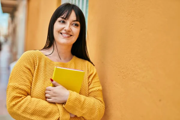 Mladá Brunetka Žena Usměvavá Šťastný Držení Knihy Opírající Zeď — Stock fotografie