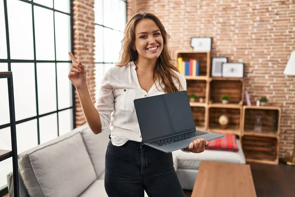 Молода Іспаномовна Жінка Використовує Ноутбук Показуючи Порожній Екран Вдома Посміхаючись — стокове фото