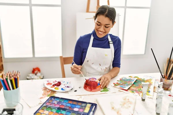 在艺术工作室里 年轻的拉丁女子笑着自信地画粘土陶瓷 — 图库照片