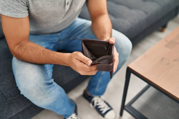 Young Hispanic Man Showing Empty Wallet Sitting Sofa Home — Stock fotografie