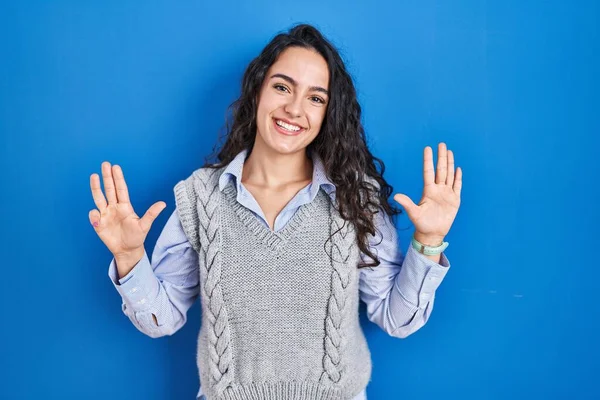 Junge Brünette Frau Steht Vor Blauem Hintergrund Und Zeigt Mit — Stockfoto