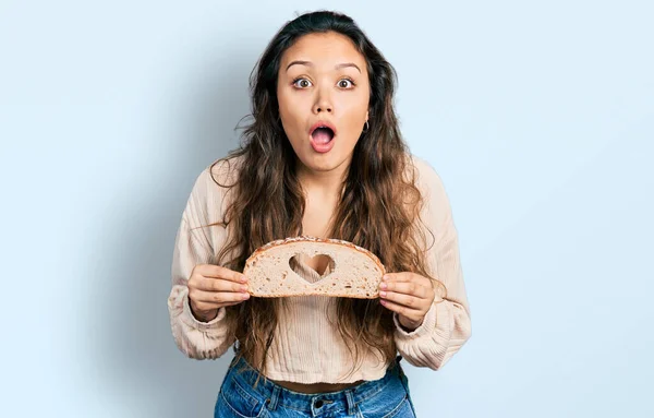 Ung Latinamerikansk Flicka Håller Bröd Med Hjärta Symbol Rädd Och — Stockfoto