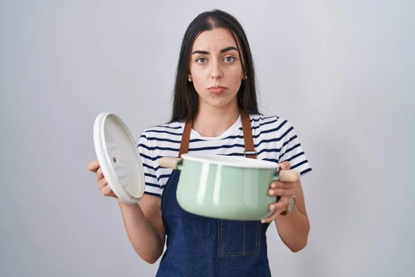Young Brunette Woman Wearing Apron Holding Cooking Pot Depressed Worry — Stockfoto