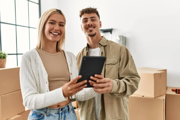 Young Caucasian Couple Smiling Happy Using Touchpad Standing New Home — Stock Photo, Image