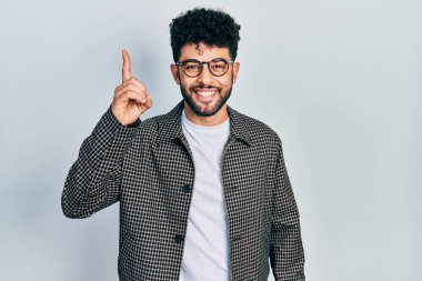 Sakallı, gözlüklü, parlak fikirli genç bir Arap. Heyecanlı ve mutlu. Bir numara.. 