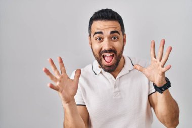 Beyaz arka plan üzerine gündelik giysiler giymiş sakallı genç İspanyol adam çılgın ve başarıyı kollarını kaldırıp heyecanla haykırarak kutluyor. Kazanan konsept 
