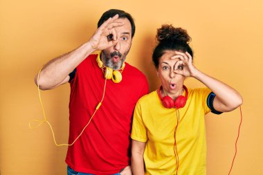 Orta yaşlı bir çift İspanyol kadın ve spor kıyafetleri ve kol bandı takan bir çift şaşırmış yüz ifadesiyle şaşırmış, parmaklarından bakan bir jest yapıyorlar. İnançsız ifade. 