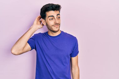 Gündelik tişört giyen genç İspanyol adam soru sorup kafasını karıştırıyor. Şüpheyle kararsız, kafa kafaya düşünerek. Düşünceli kavram. 