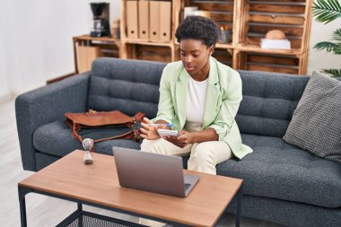 Afrika kökenli Amerikalı kadın psikolog, psikoloji merkezindeki kanepede oturuyor.