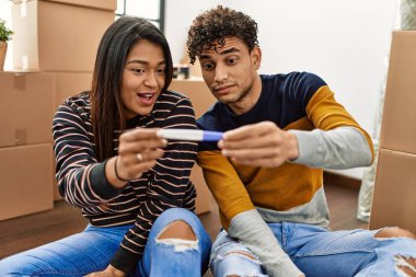 Genç Latin çift yeni evlerinde yerde otururken hamilelik testi yaparken şaşırdılar..