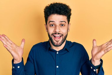 Sakallı genç Arap adam çılgın kutlamalar yapıyor ve kolları açık, gözleri açık heyecanla haykırıyor. Kazanan konsept 