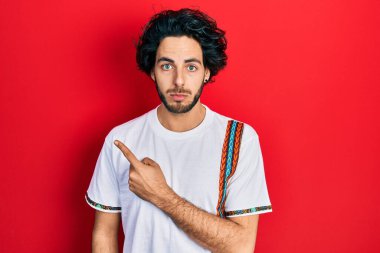 Yakışıklı ispanyol adam parmaklarını yana doğru gösteriyor. Depresyonda ve endişe içinde ağlıyor, kızgın ve korkmuş. hüzünlü ifade. 