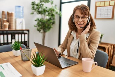 Ofiste çalışırken gülümseyen Kafkasyalı bir çağrı merkezi ajanı..