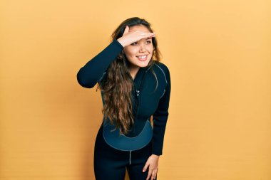 Genç İspanyol kız dalgıç neoprene üniforması giyiyor. Çok mutlu ve gülümsüyor. Çok uzaklara bakıyor. arama kavramı. 