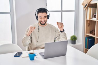 Genç Arap adam evde oturmuş müzik dinliyor.