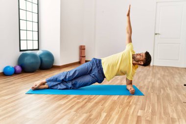 Genç Arap sporcu adam spor merkezinde yoga antrenmanına konsantre ol..