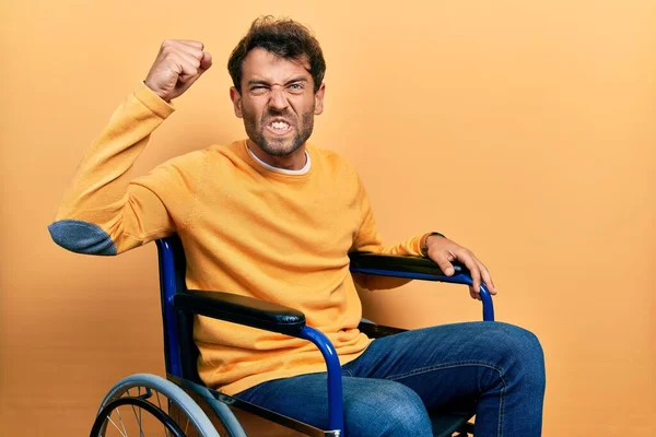 Pohledný Muž Vousy Sedící Invalidním Vozíku Rozzlobený Šílený Zvedající Pěst — Stock fotografie