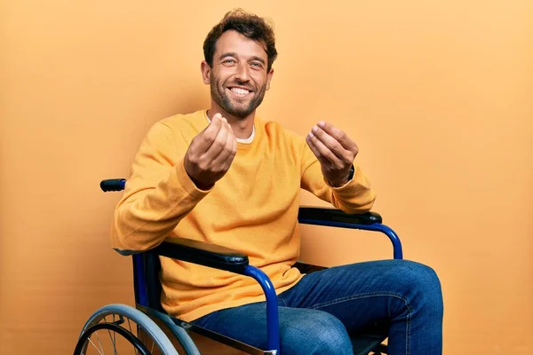 Homem Bonito Com Barba Sentado Cadeira Rodas Fazendo Gesto Dinheiro — Fotografia de Stock