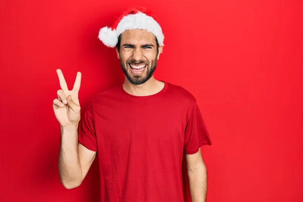Mladý Hispánec Vánočním Kloboukem Usmívající Šťastnou Tváří Mrkající Kameru Předvádějící — Stock fotografie