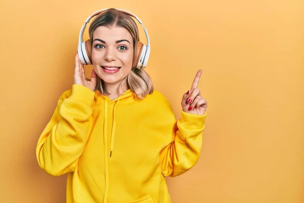 Beautiful Caucasian Woman Listening Music Using Headphones Surprised Idea Question — Stock Photo, Image
