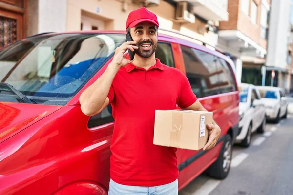 Young Hispanic Man Courier Talking Smartphone Holding Package Street — Foto de Stock