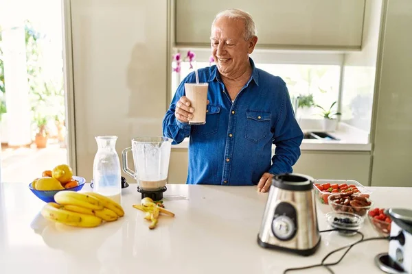 Hombre Mayor Sonriendo Confiado Sosteniendo Vaso Batido Cocina —  Fotos de Stock